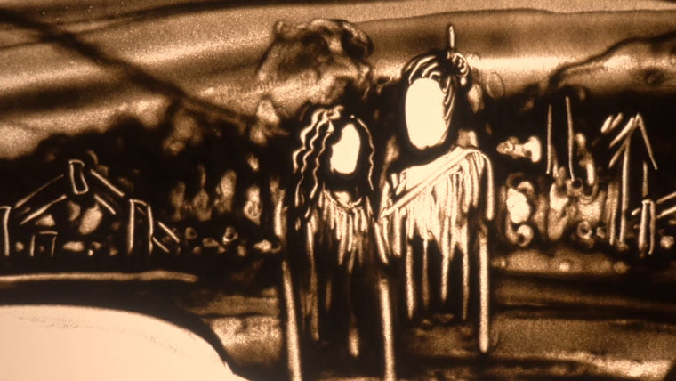 A man and a woman drawn out of sand on a lightbox, in the background there is a drawing of a wharenui.