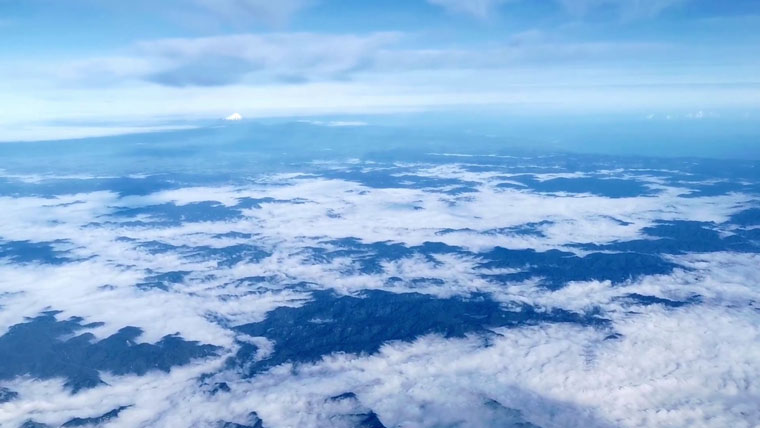Aerial photo above the clouds, Mt Taranaki is visible in the distance.