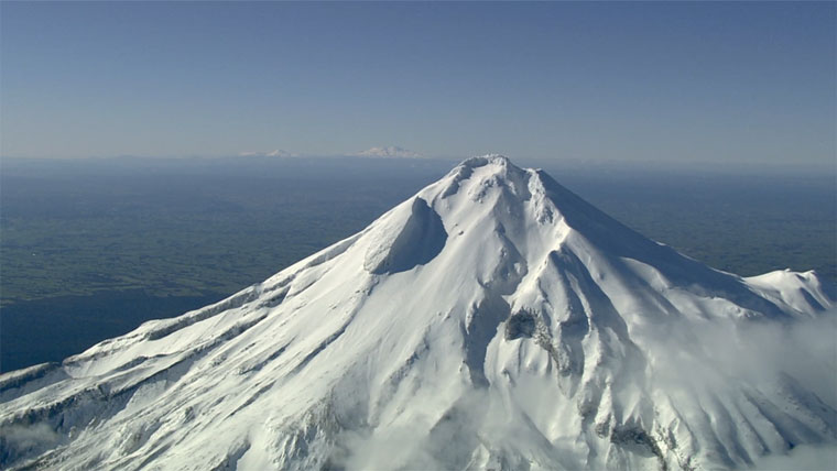 A view of Te Kaahui Maunga from the peak of Taranaki Maunga, with Ruapehu, Tongariro, and Ngauruhoe in the distance.