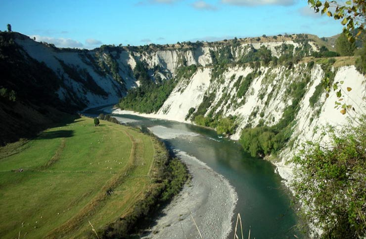 River with high cliffs with exposed white soil.
