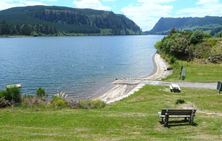 Grassy area with seats looking out to sheltered harbour.