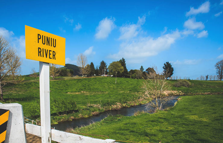Road sign, 'Puniu River' on a bridge over a creek