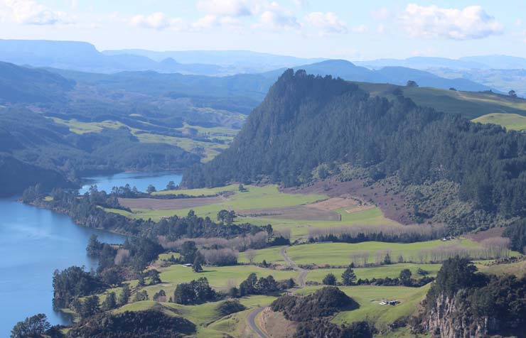 Looking down on a river valley with forest covered hill on one side.