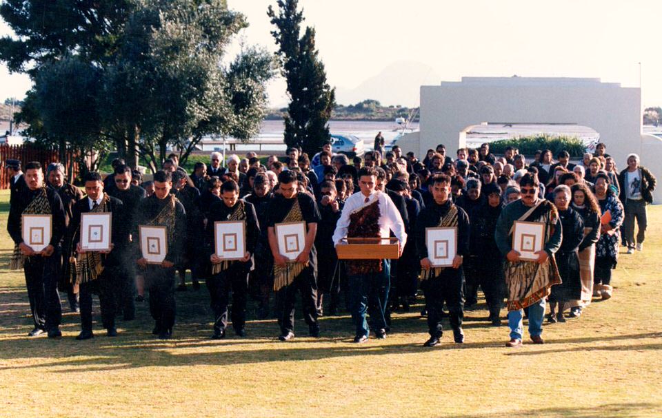 Members of Ngāi Taiwhakaea II, Ngāti Hikakino, and Ngāi Te Rangihouhiri II, at Te Whare o Toroa Marae, Whakatāne, 6 July 1994. Descendants mourn while bringing images of Ngāti Awa men imprisoned and executed for the 1865 murder of James Fulloon onto the marae. Image supplied by <a class='external-link' href='https://www.ngatiawa.iwi.nz/' target='_blank' rel='noopener'>Te Rūnanga o Ngāti Awa</a>