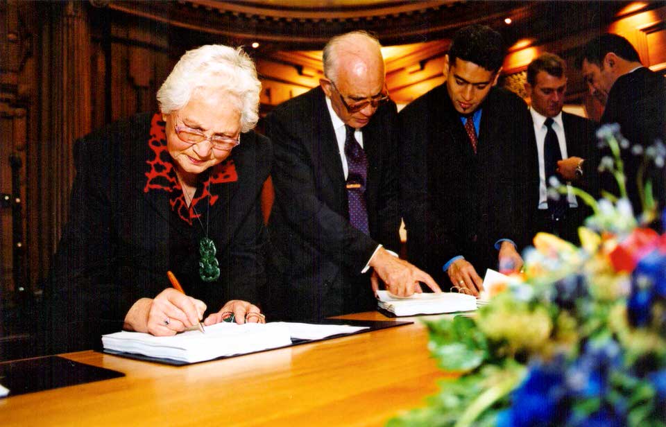 He kaumātua o Ngāti Awa e haina ana i te Whakaaetanga Whakataunga o Ngāti Awa i te Paremata, 2003. He pikitia nā Te Rūnanga o Ngāti Awa
