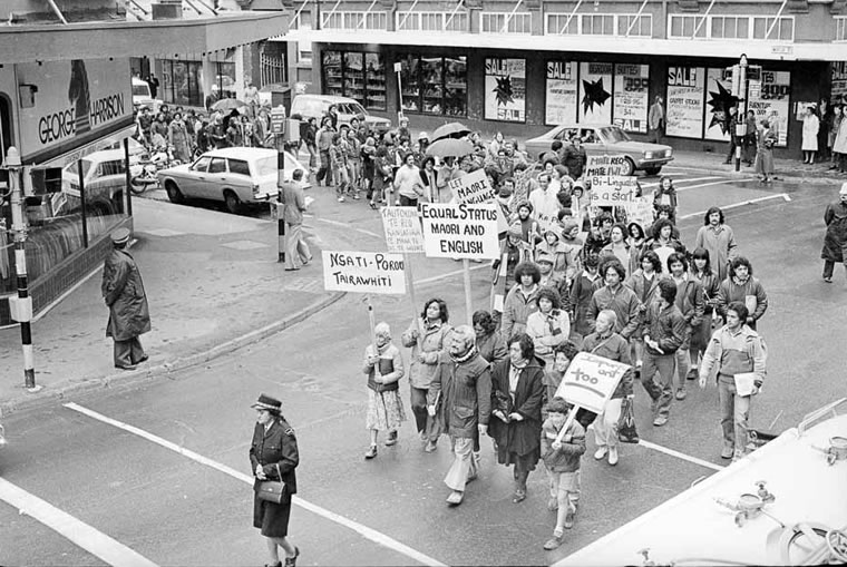 Group of people marching with protest signs.
