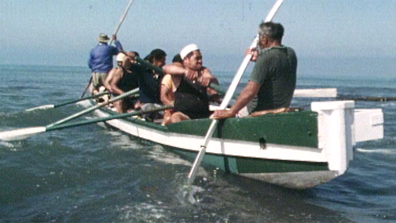 Men paddling a waka on the ocean
