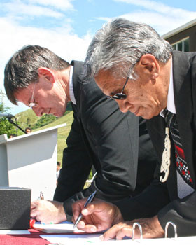Minister Chris Finlayson and George Rangitutia signing a document